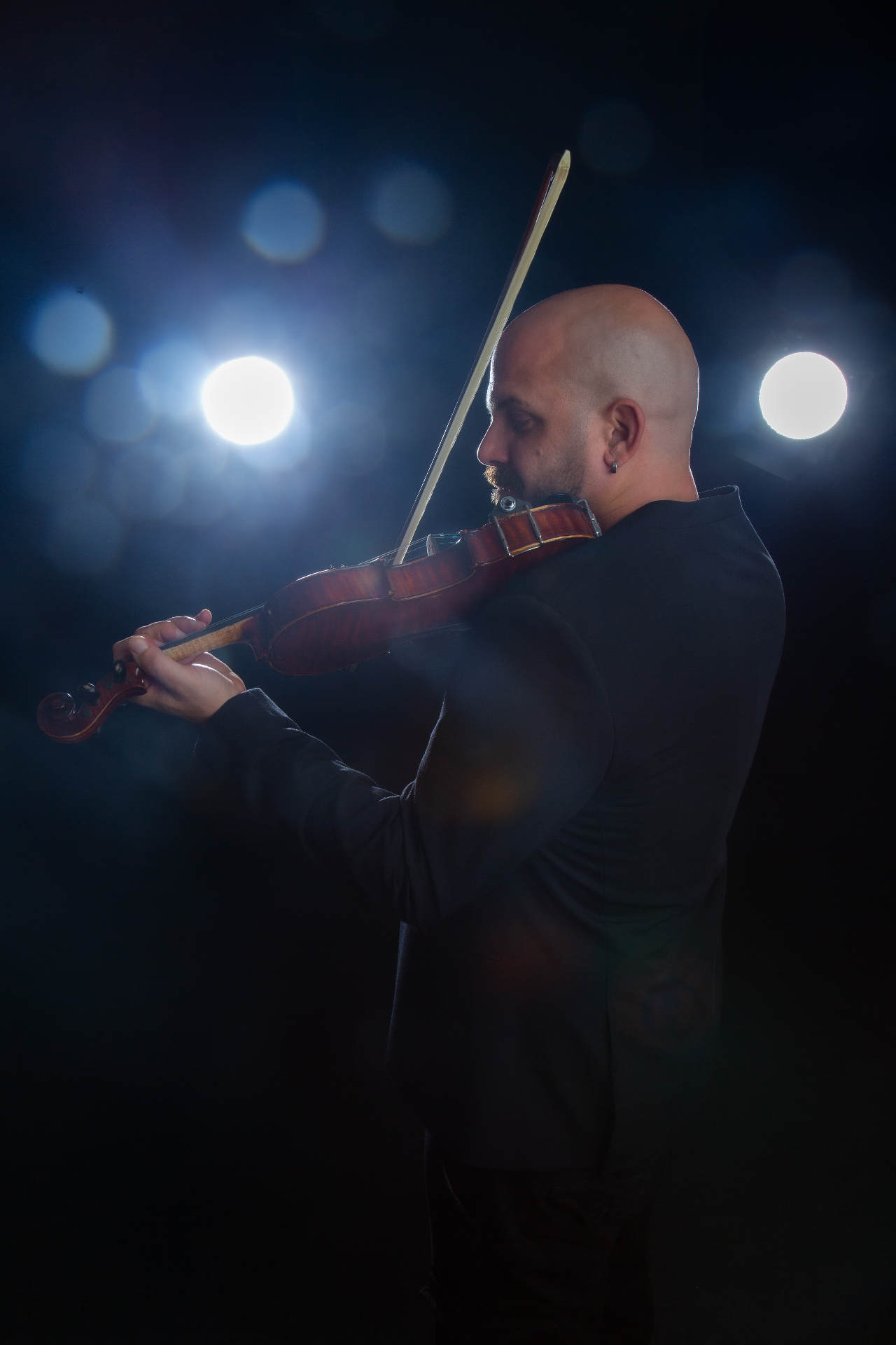 Playing violin on stage with bokeh lights